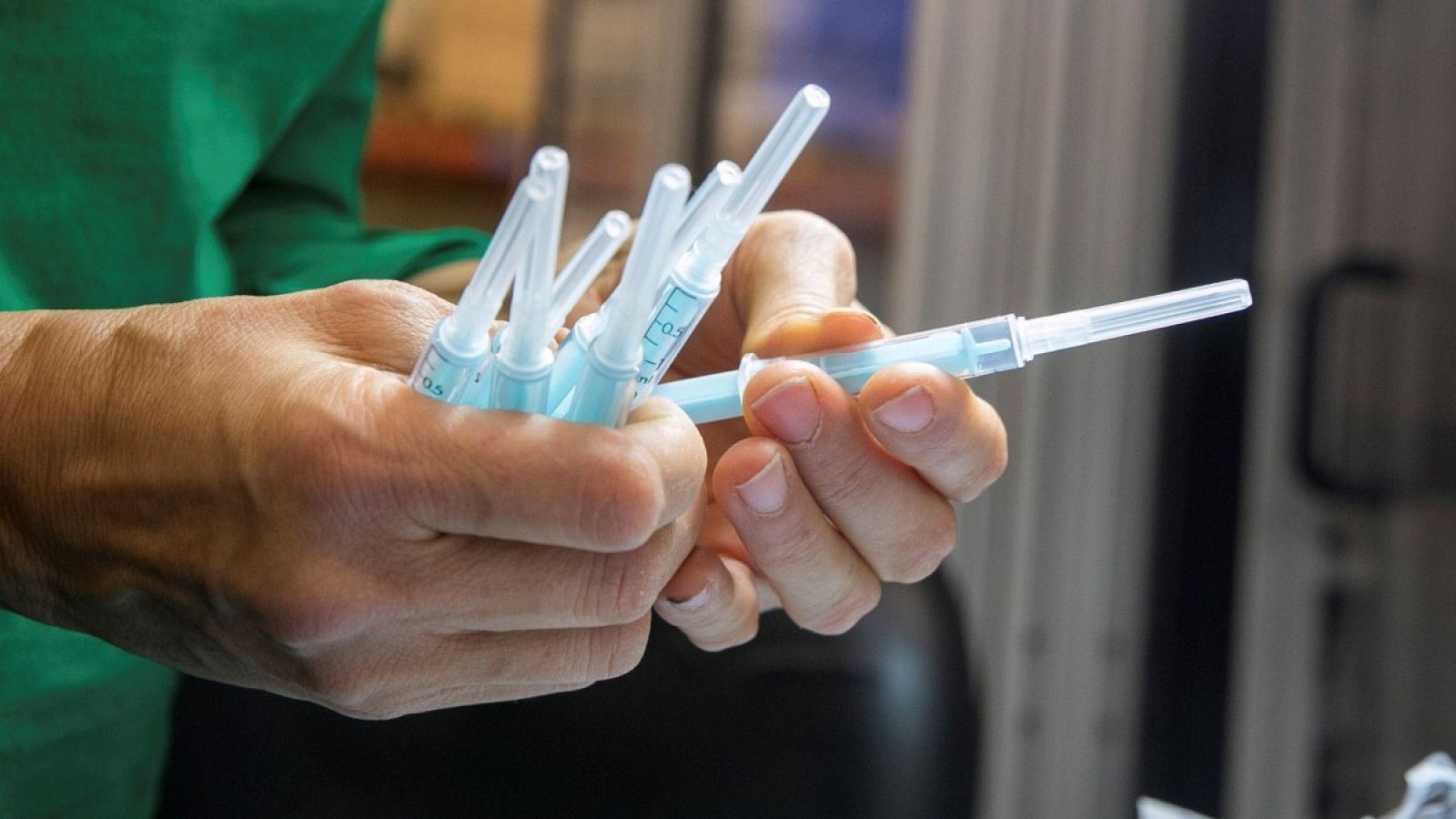 Una operaria inspecciona unas muestras de la jeringuilla para administrar la vacuna de la COVID-19.