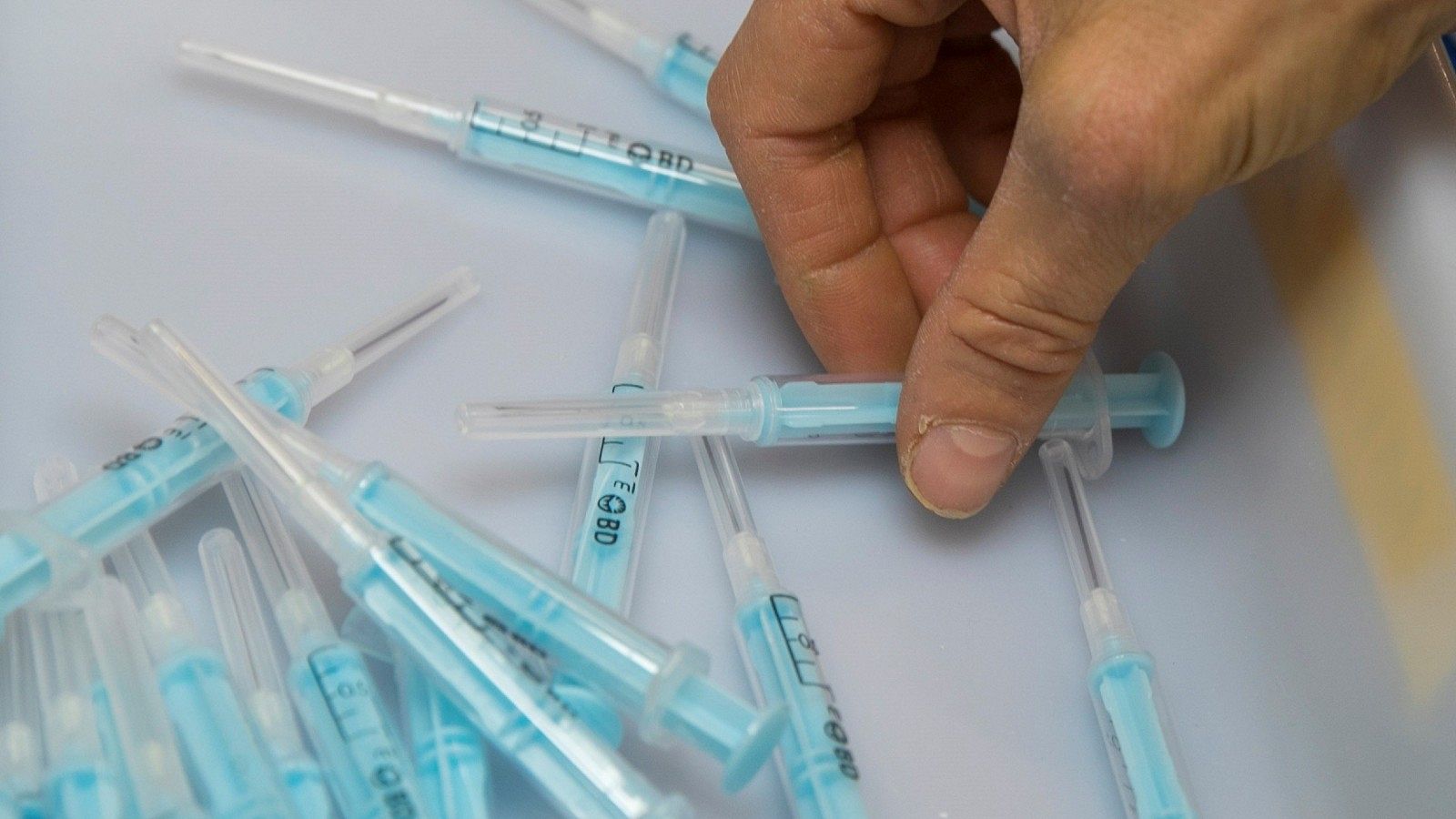 Una operaria de la planta de la empresa Becton Dickinson de Fraga (Huesca), inspecciona unas muestras de la jeringuilla que fabrican para administrar la vacuna contra el coronavirus.