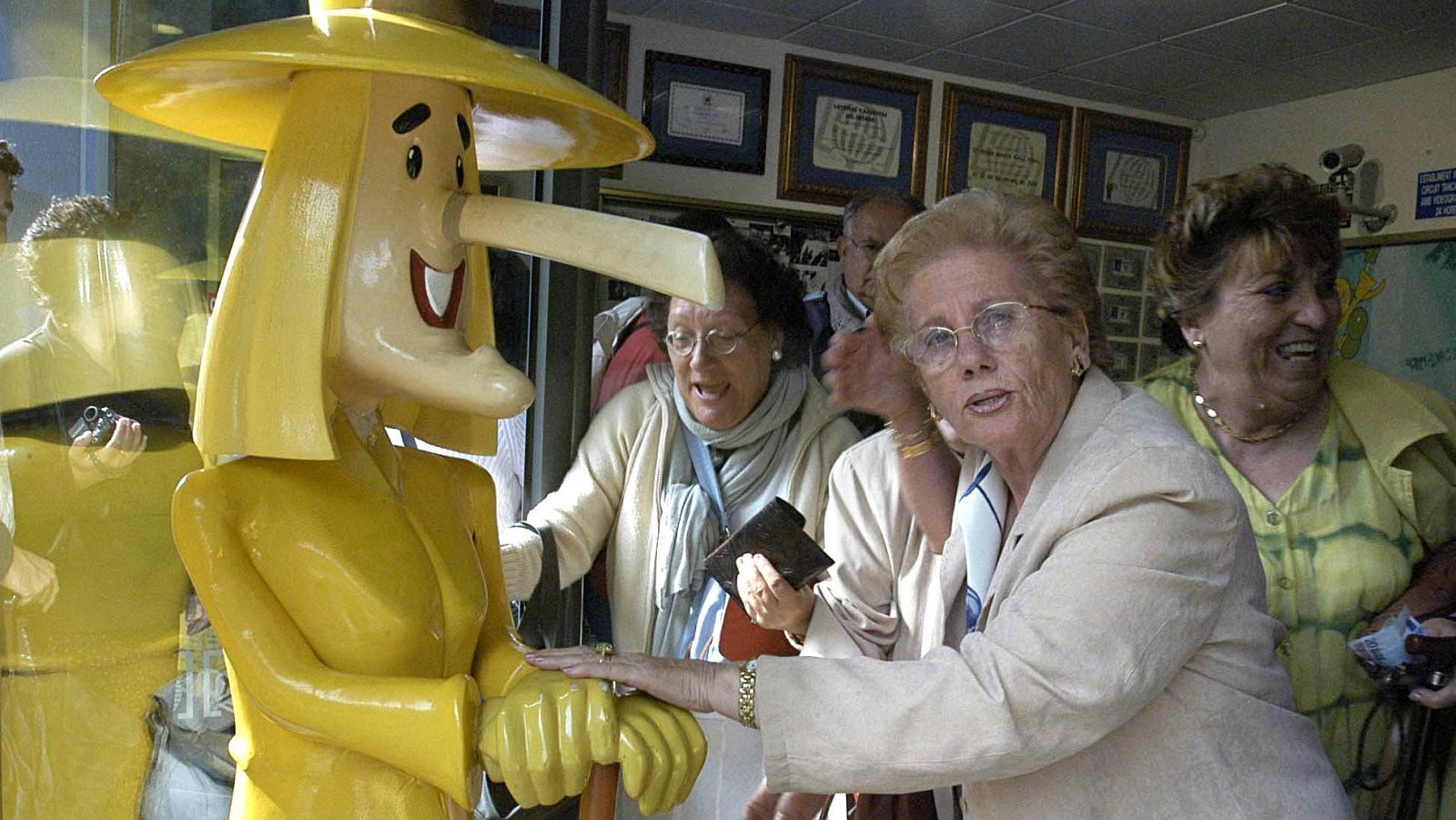Una mujer pasa por las manos de "La Bruixa d'Or" un décimo de Lotería, en una foto de archivo