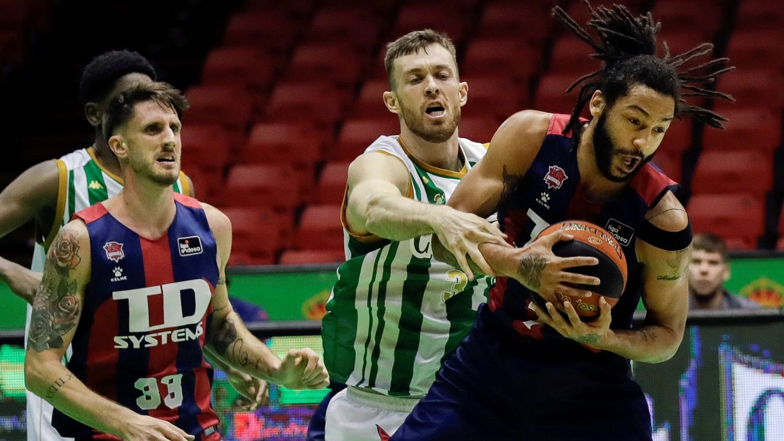 El pívot australiano del Coosur Real Betis, Nick Kay, y los jugadores del TD Systems Baskonia, Pierria Henry (d) y Achille Polonara (i).