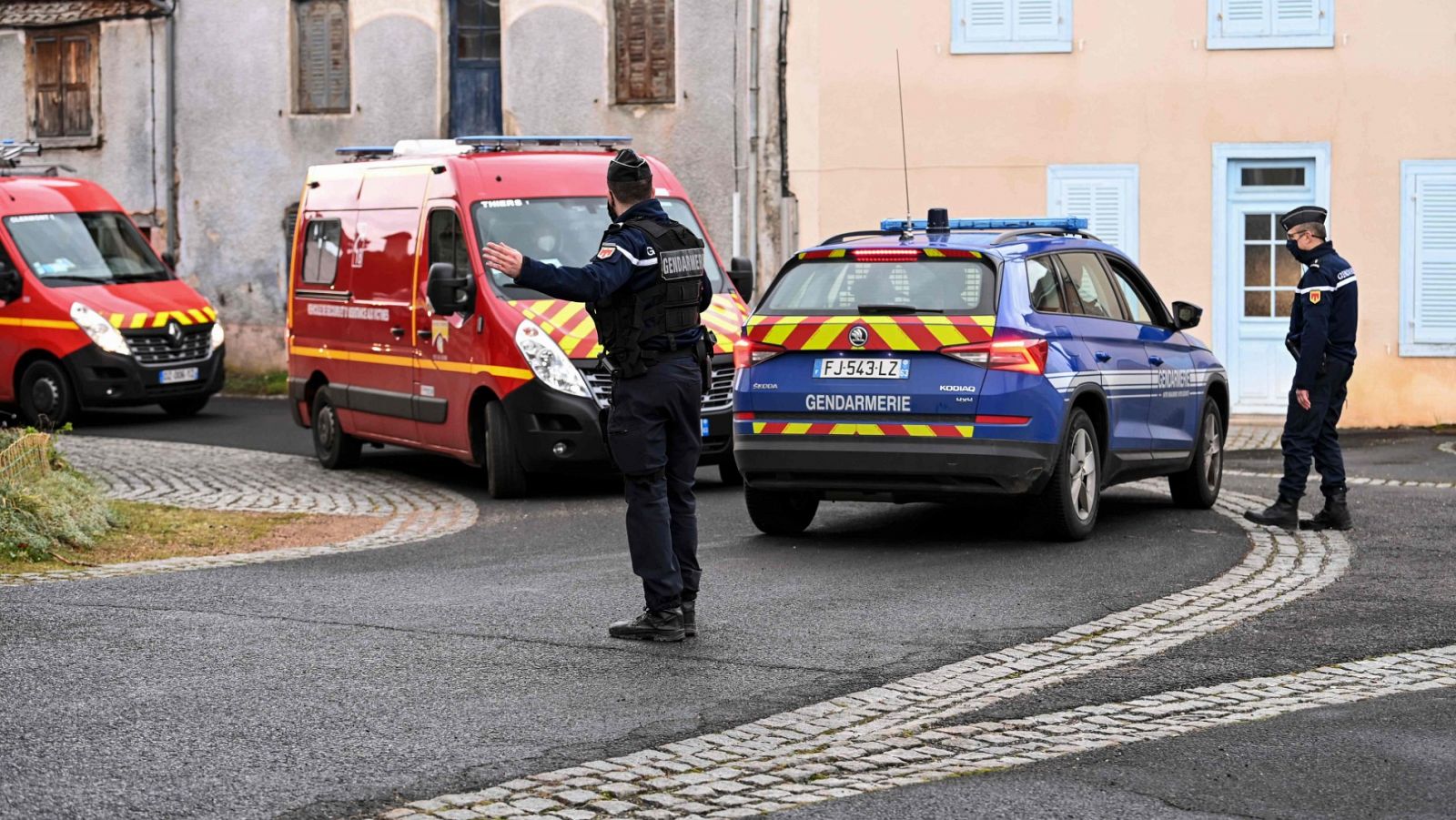 Un agente de Policía junto a un coche de bomberos en Saint-Just, donde tres gendarmes han muerto por disparos en un presunto caso de violencia de género