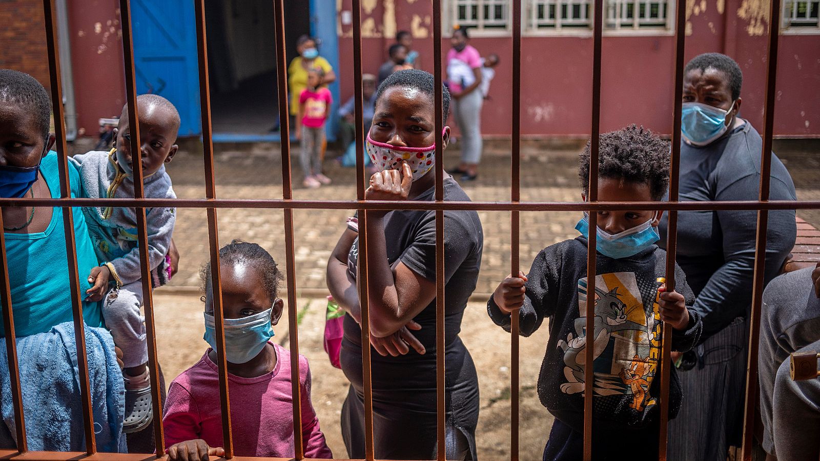 Madres con sus hijos esperan para recibir alimentos básicos en Johannesburgo, Sudáfrica.