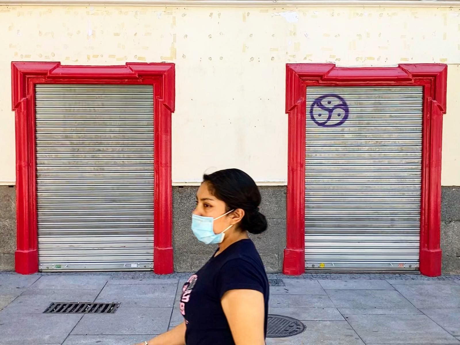Una mujer pasea frente a un comercio cerrado del centro de Madrid