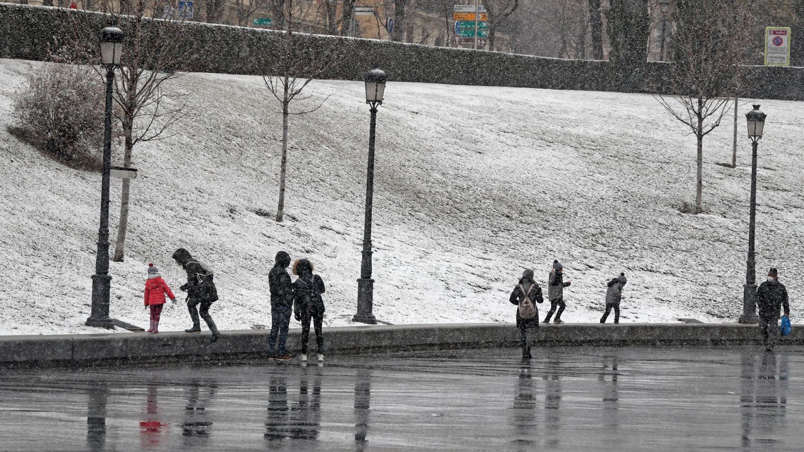Varias personas ven caer la nieve a las puertas del Museo del Prado, en Madrid capital