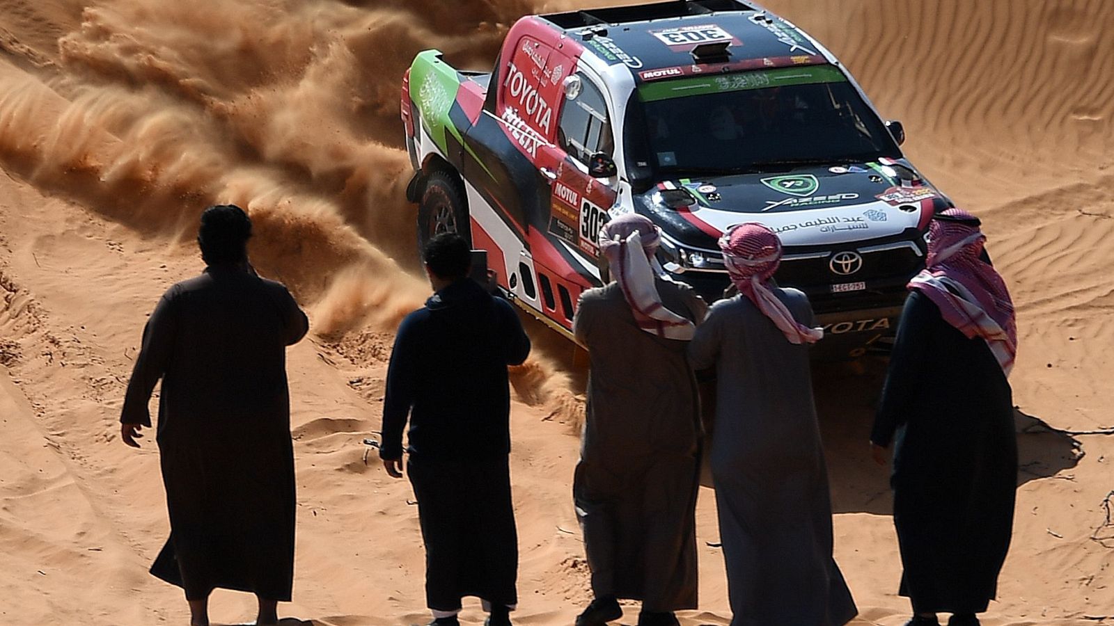 Un grupo de personas presencia el paso del Yazeed Al Rajhi durante el rally Dakar
