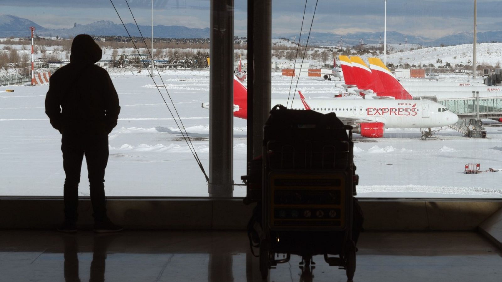 Una persona observa los aviones en la T-4 del aeropuerto de Barajas, Madrid.