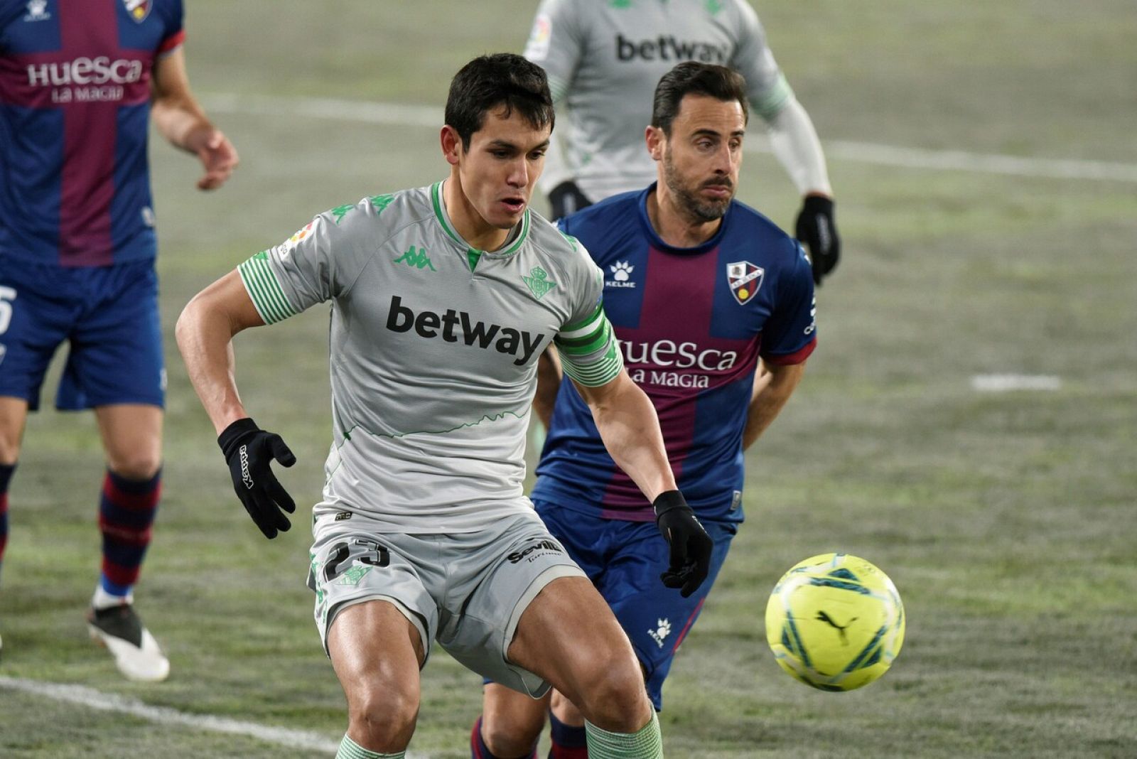 El defensa de la SD Huesca Pedro López (d) lucha con el argelino Aissa Mandi, del Real Betis.