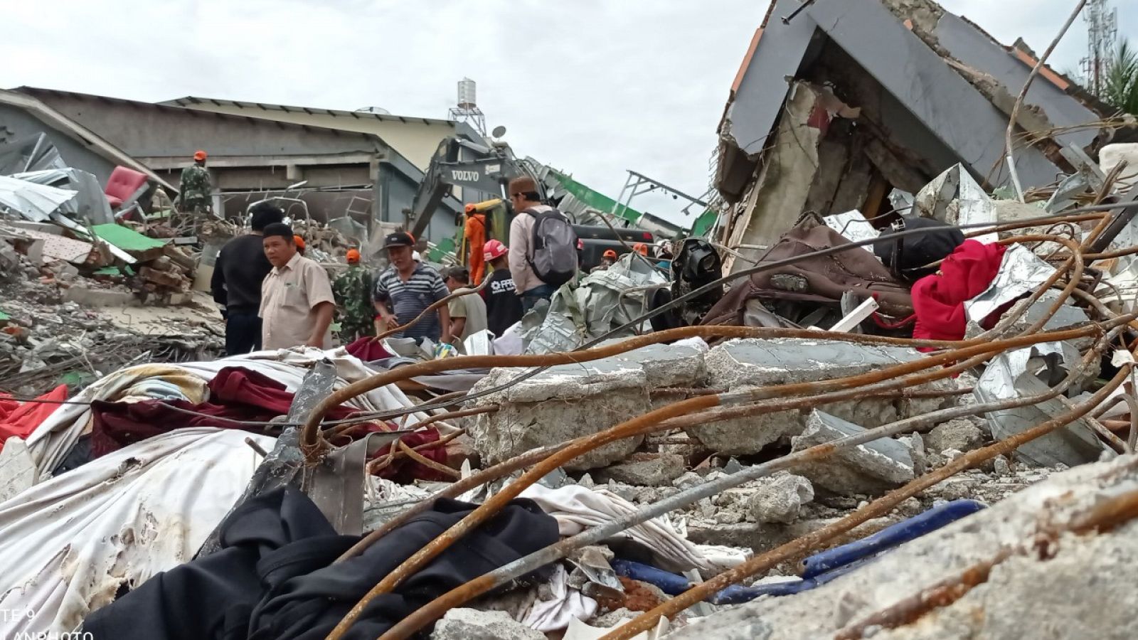 Gente andando entre los escombros de casas derruidas por el terremoto en la isla de Célebes, en el centro de Indonesia.