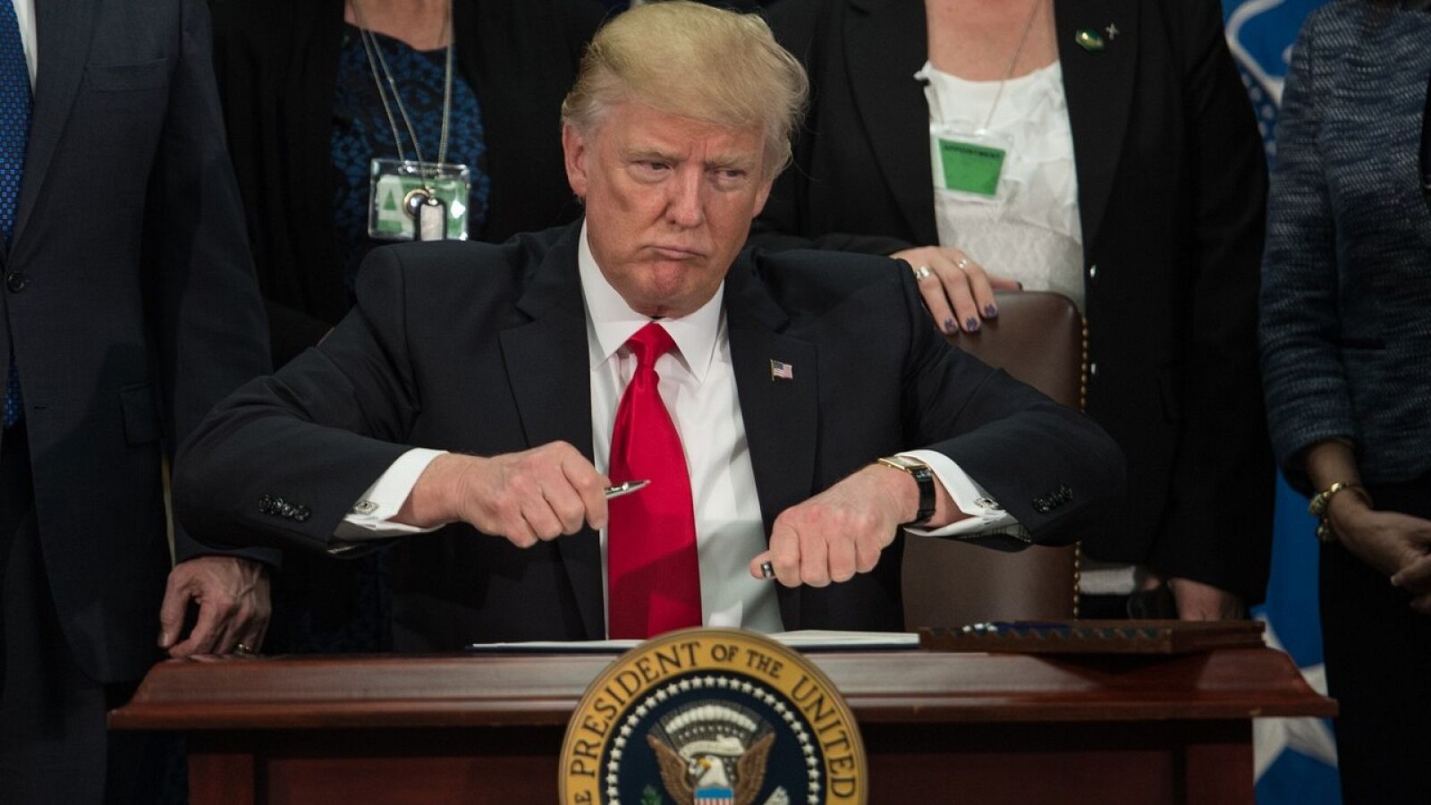 El presidente de EE.UU., Donald Trump, saca su pluma para firmar la orden ejecutiva para la construcción del muro con México, el 25 de enero de 2017. NICHOLAS KAMM / AFP