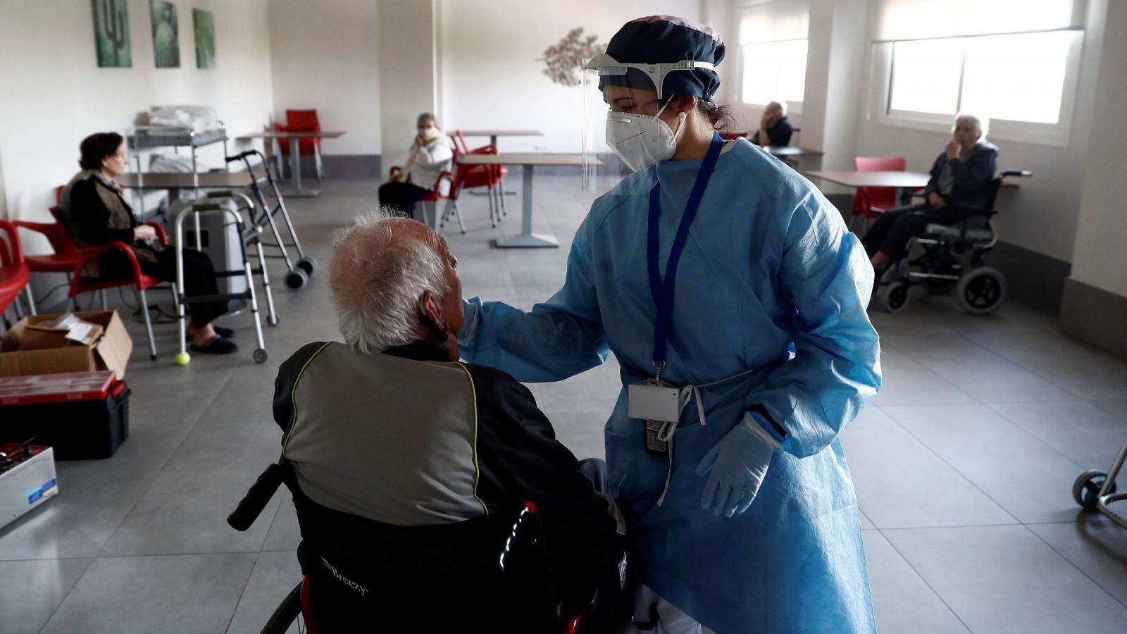  Imagen de archivo en la que una sanitaria atiende a un anciano en una residencia de Madrid.
