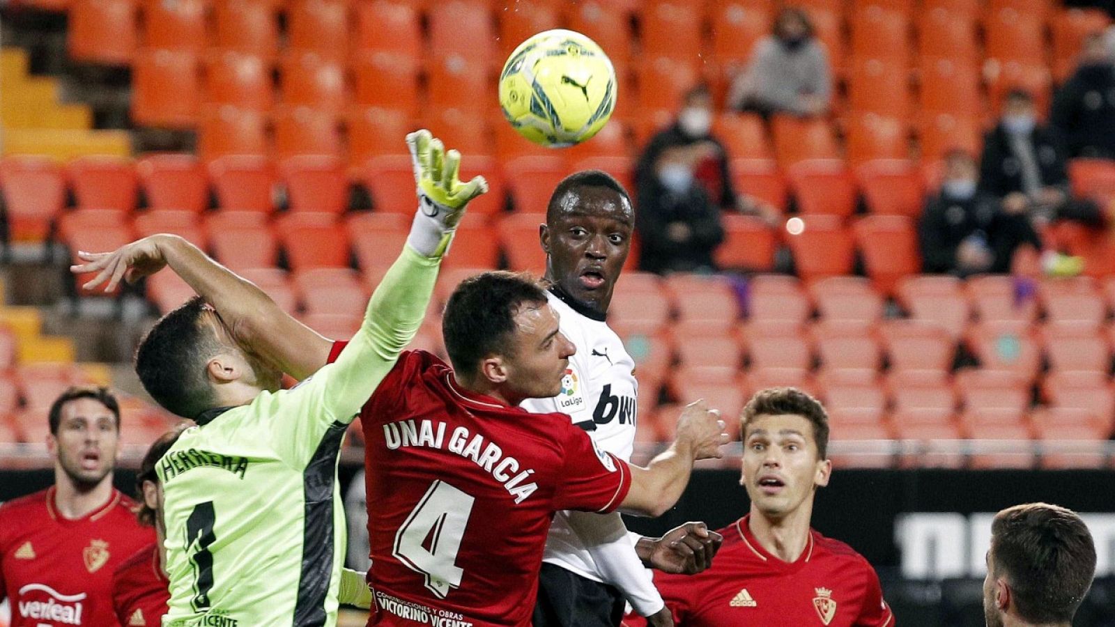 El defensa francés del Valencia Mouctar Diakhaby (c) trata de cabecear un balón durante el partido ante el Osasuna.