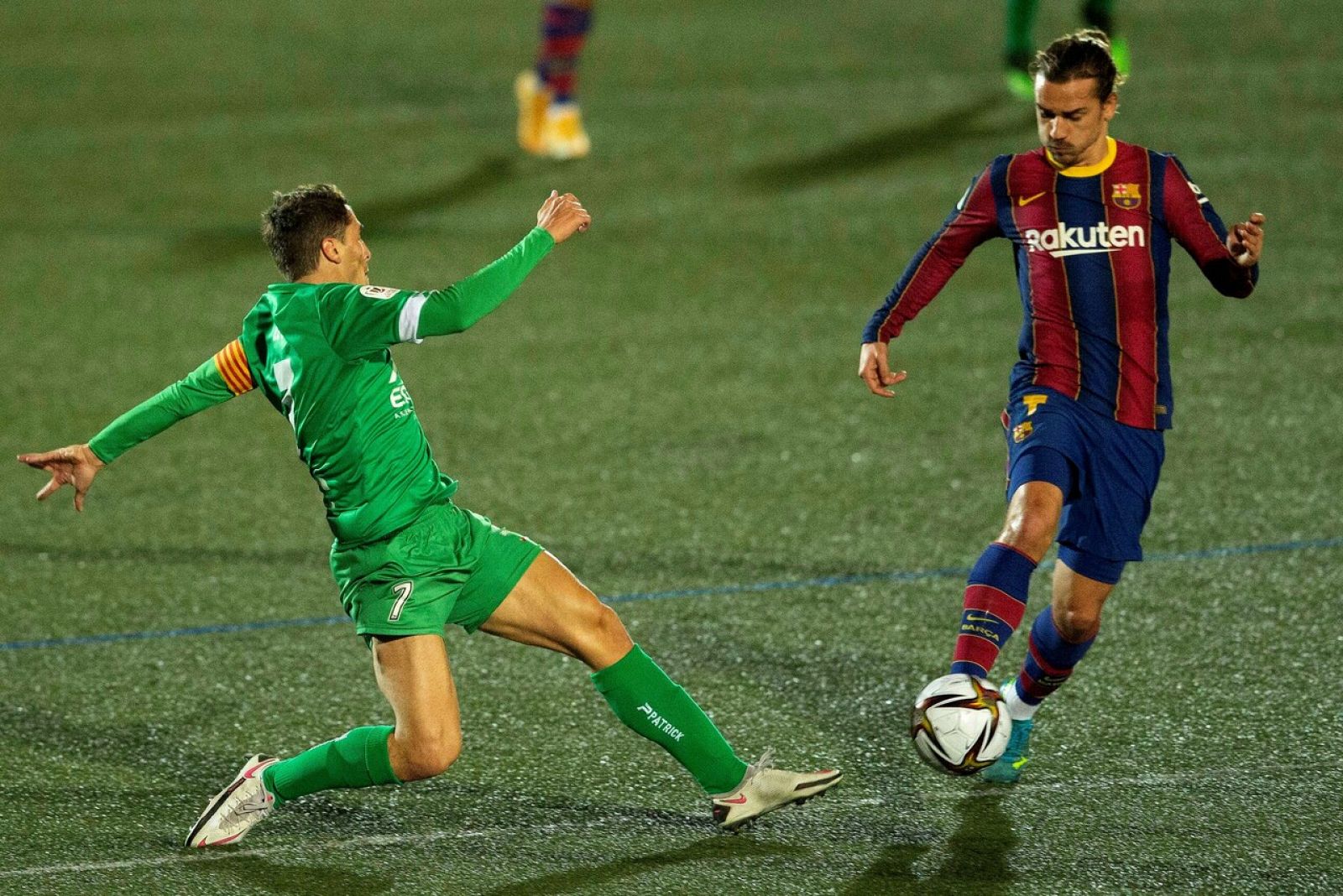 El centrocampista del Cornellá Eloy Gila (i) lucha con el francés Antoine Griezmann, del FC Barcelona
