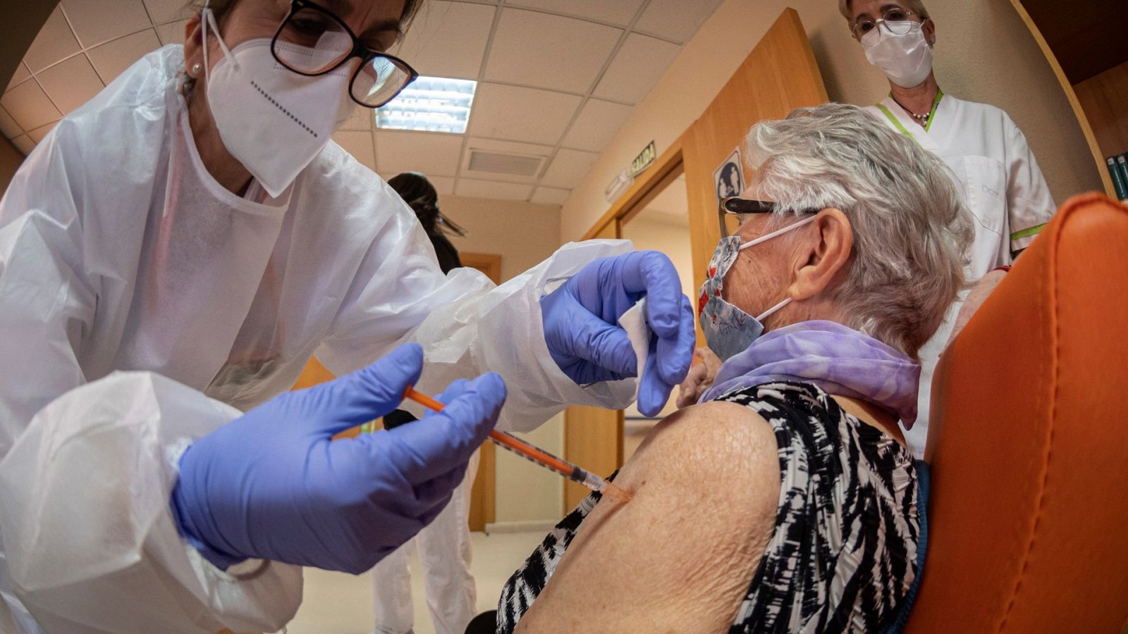 Una usuaria de una residencia de ancianos de Alcalá de Henares (Madrid) recibe una dosis de la vacuna contra el covid.