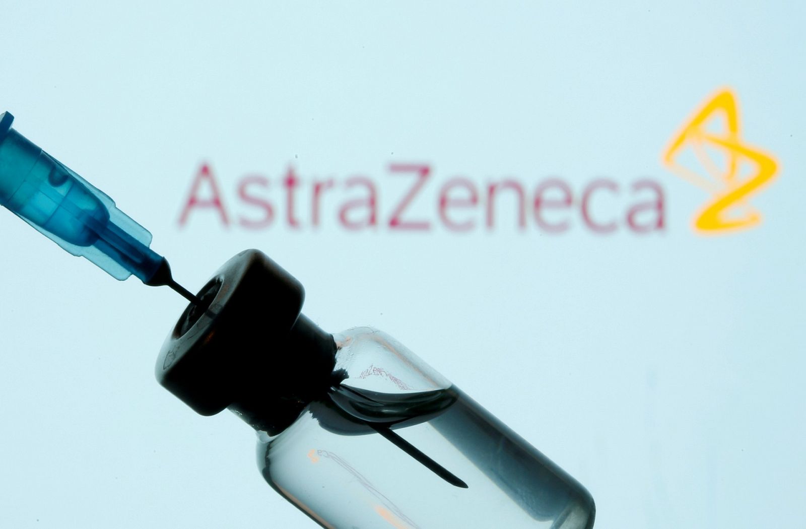 Un vial y una jeringuilla delante del logo de AstraZeneca