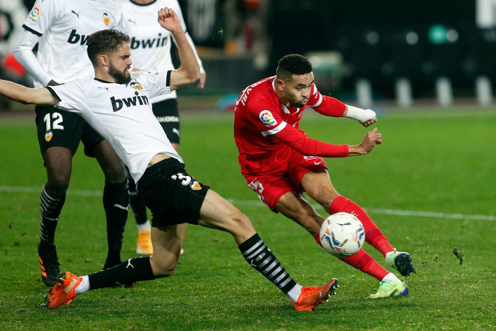 El jugador del Valencia, Molina, y En Nesyri (d), del Sevilla FC durante un encuentro de Liga