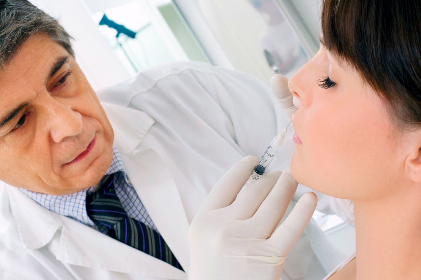 young caucasian woman receiving an injection of botox from a doctor