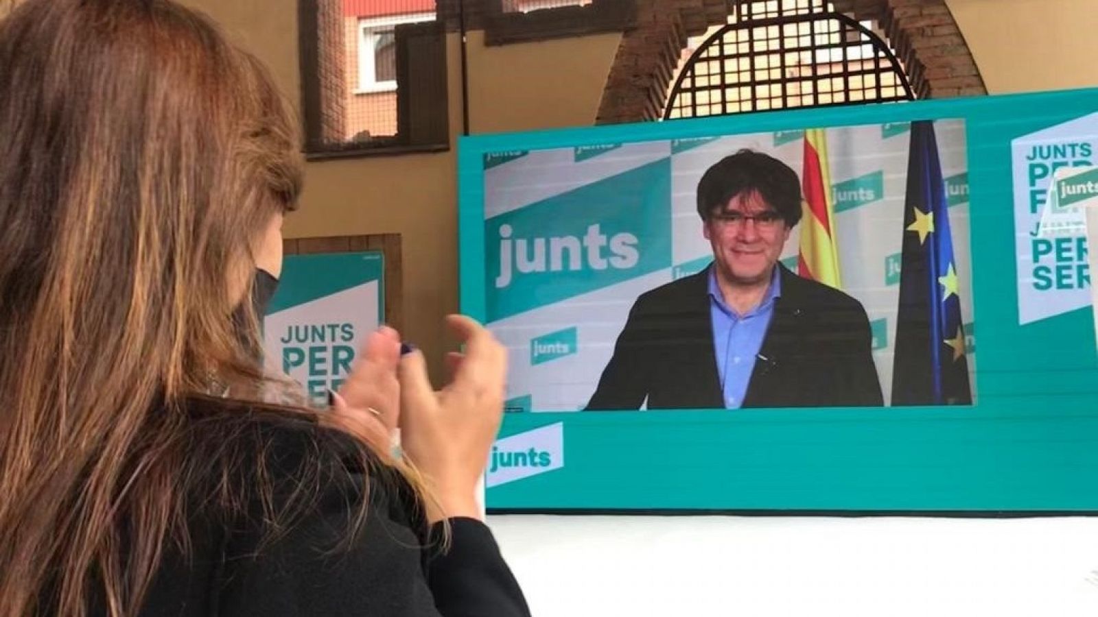 La candidata de Junts, Laura Borràs, escucha la intervención de Carles Puigdemont por videoconferencia en un acto electoral en Sant Cugat del Vallès.