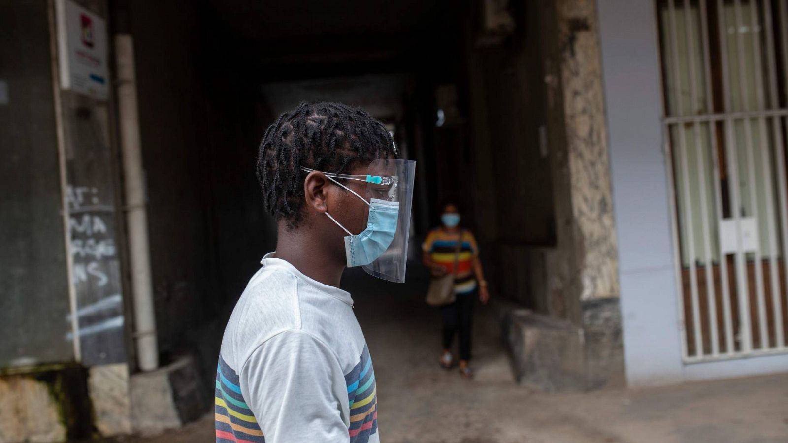 Un hombre camina con una mascarilla y una pantalla para protegerse del coronavirus en Maputo, Mozambique
