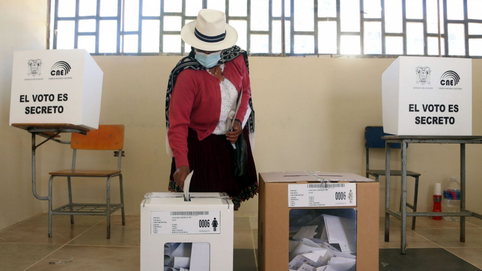 Imagen de archivo del 7 de febrero de 2021 de una mujer depositando su voto en un centro electoral de Cuenca, Ecuador, durante la primera vuelta de las elecciones presidenciales en el país.