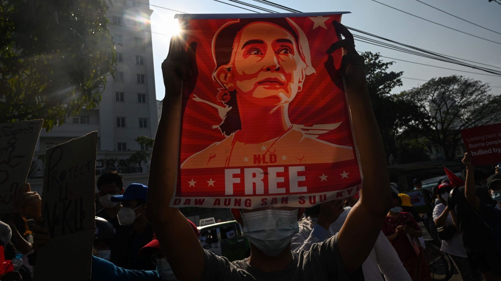 Un manifestante muestra un cartel con Aung San Suu Kyi frente al Banco Central de Rangún.