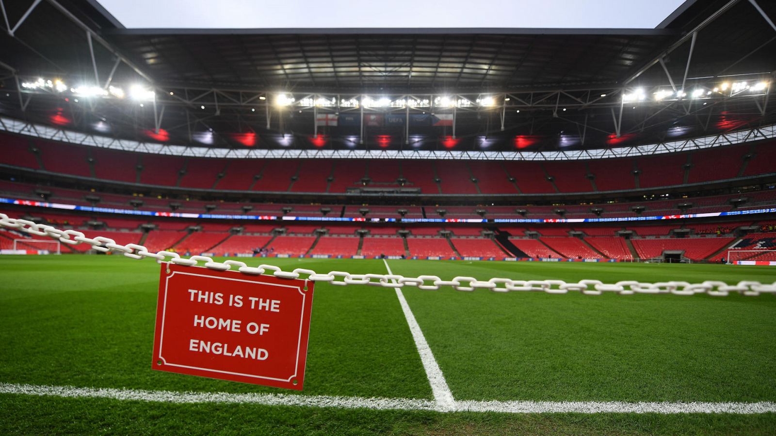 Vista del estadio de Wembley vacío con un letrero en primer plano con la leyenda, en inglés "Esta es la casa de Inglaterra"