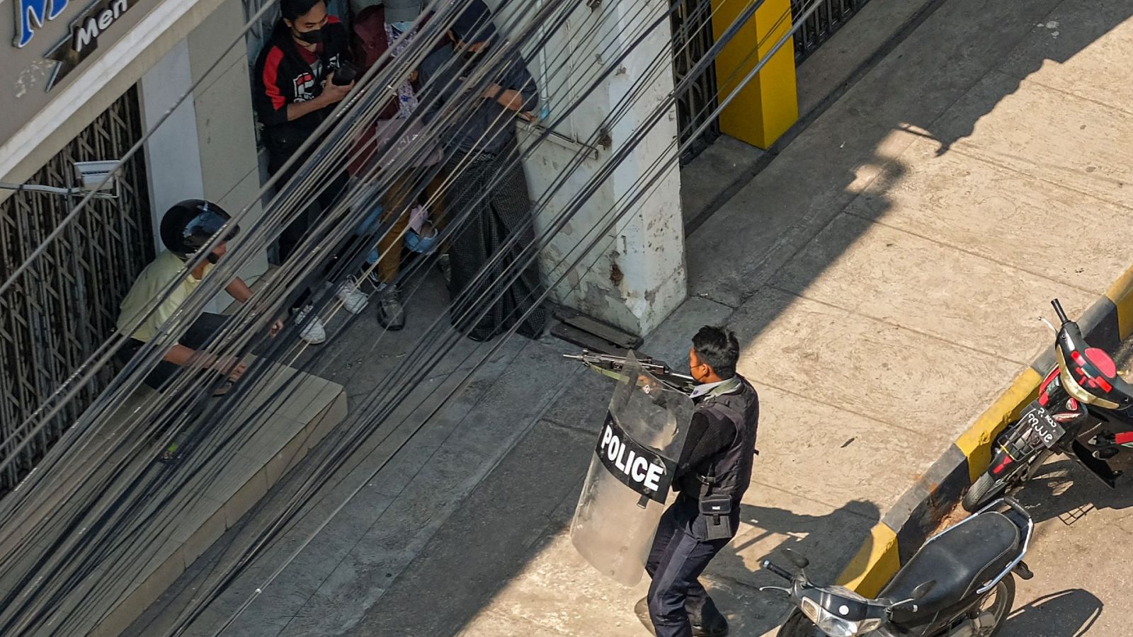 Un policía apunta con su arma a la gente en Taunggyi, una ciudad en el estado de Shan, Birmania, el 28 de febrero de 2021