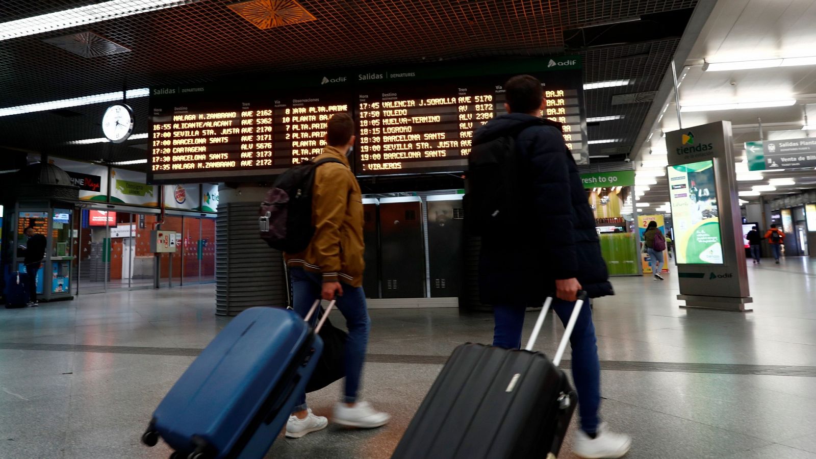 Dos viajeros en un vestíbulo en la estación de Atocha de Madrid.