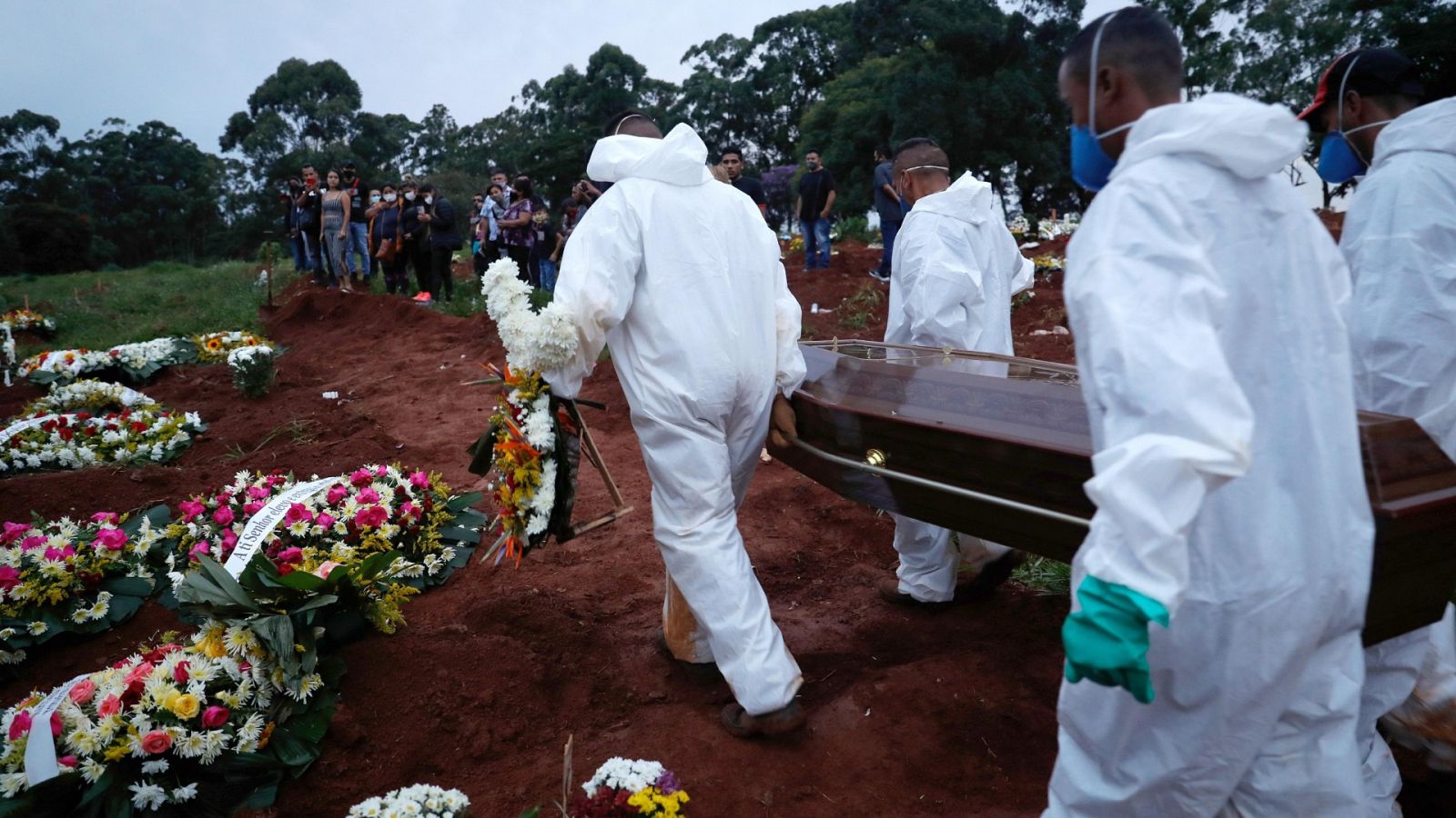 Un grupo de personas se encargan de realizar el entierro de una víctima del coronavirus este jueves en el cementerio Viola Formosa en Sao Paulo (Brasil).