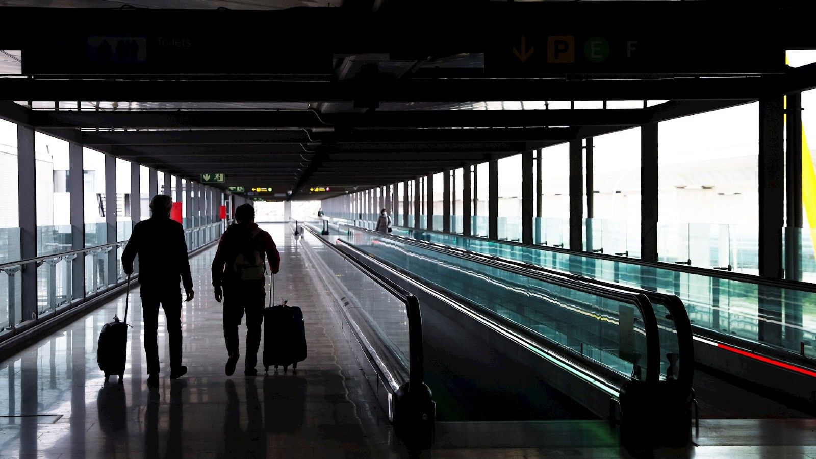 Dos pasajeros cruzan una de las terminales del Aeropuerto Adolfo Suárez Madrid-Barajas.