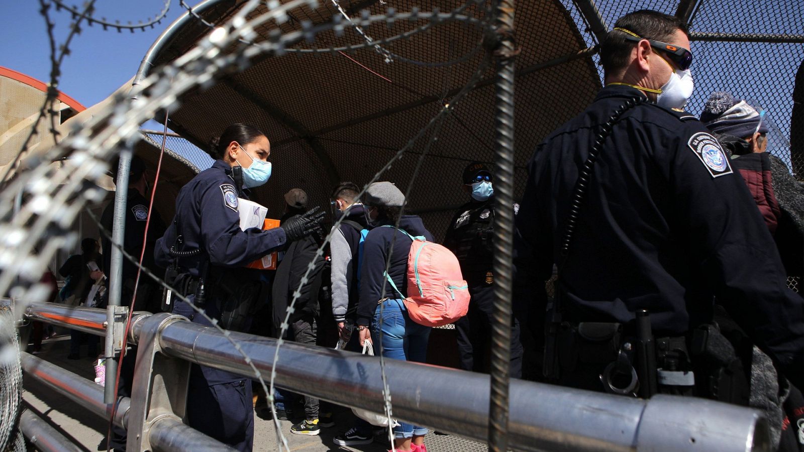 Policías estadounidenses supervisan el paso de inmigrantes centroamericanos, como parte del Protocolo de Protección de Migrantes (MPP,) este jueves en el puente internacional Paso del Norte en Ciudad Juárez, en el estado de Chihuahua (México).