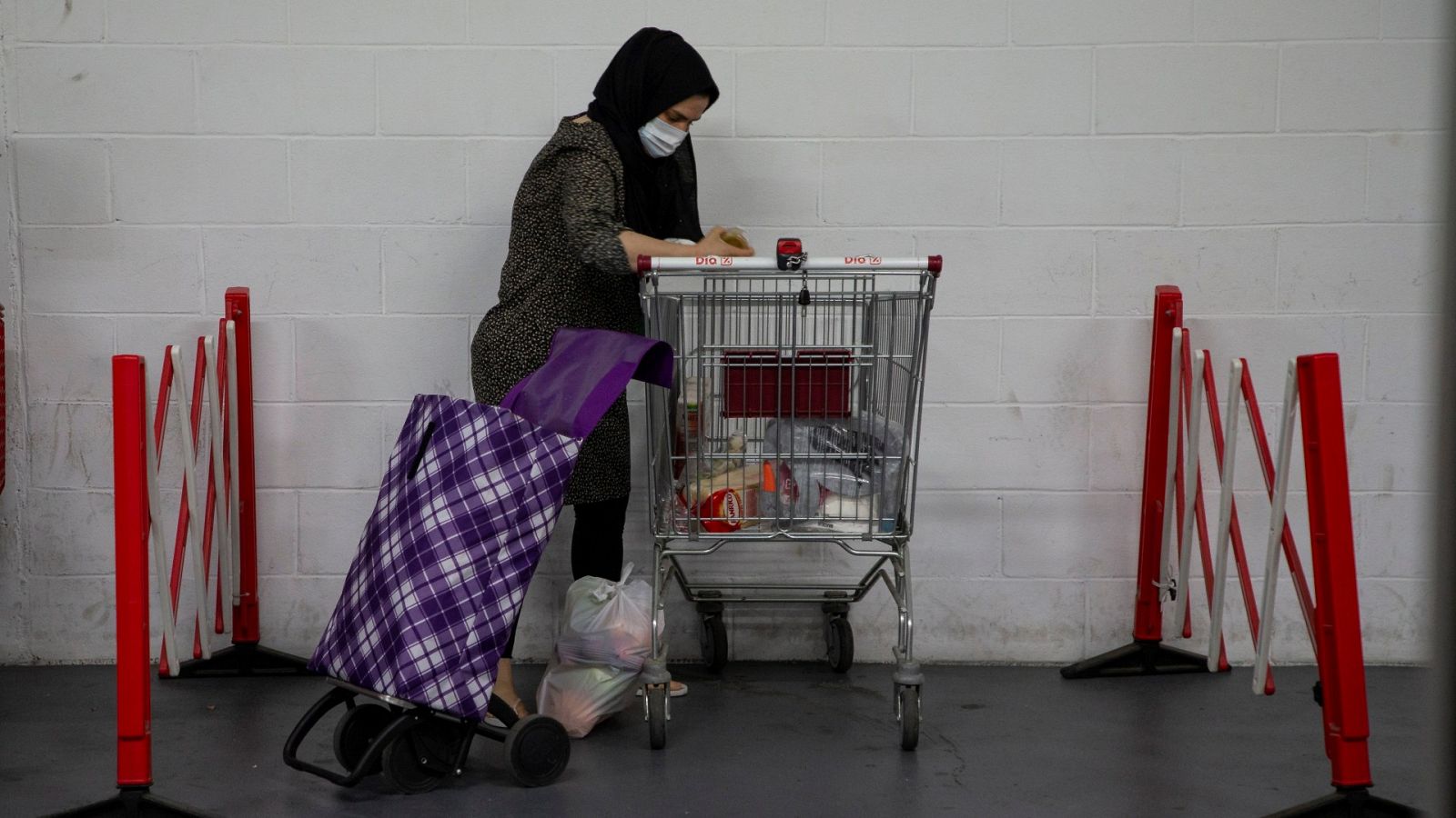 Una mujer recoge un lote de comida en el almacén de la Cruz Roja en Mataró (Barcelona)