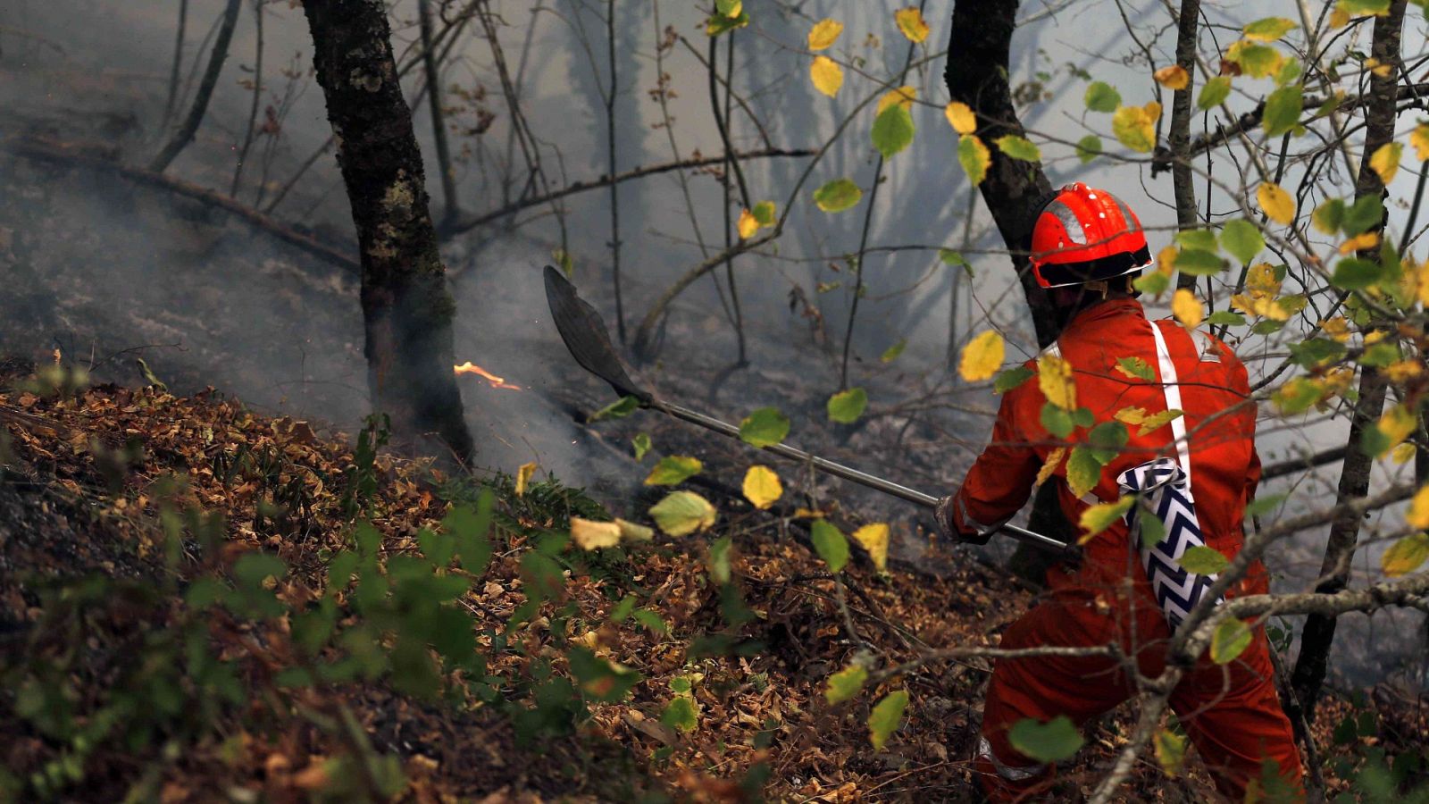 Un bombero participa en las labores de extinción de un incendio en Asturias