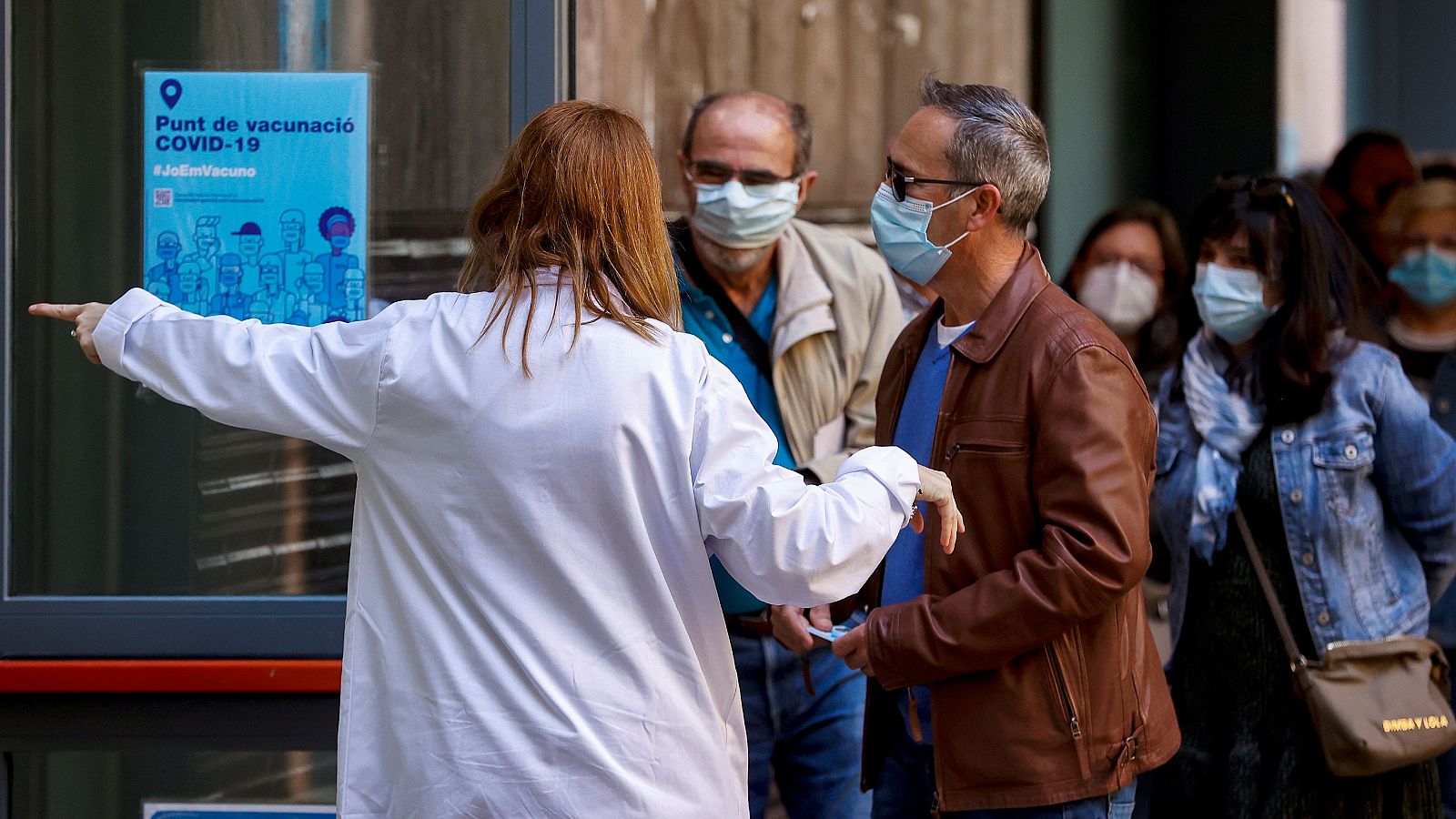 Varias personas hacen cola en el centro de vacunación UB Raval, en Barcelona. 