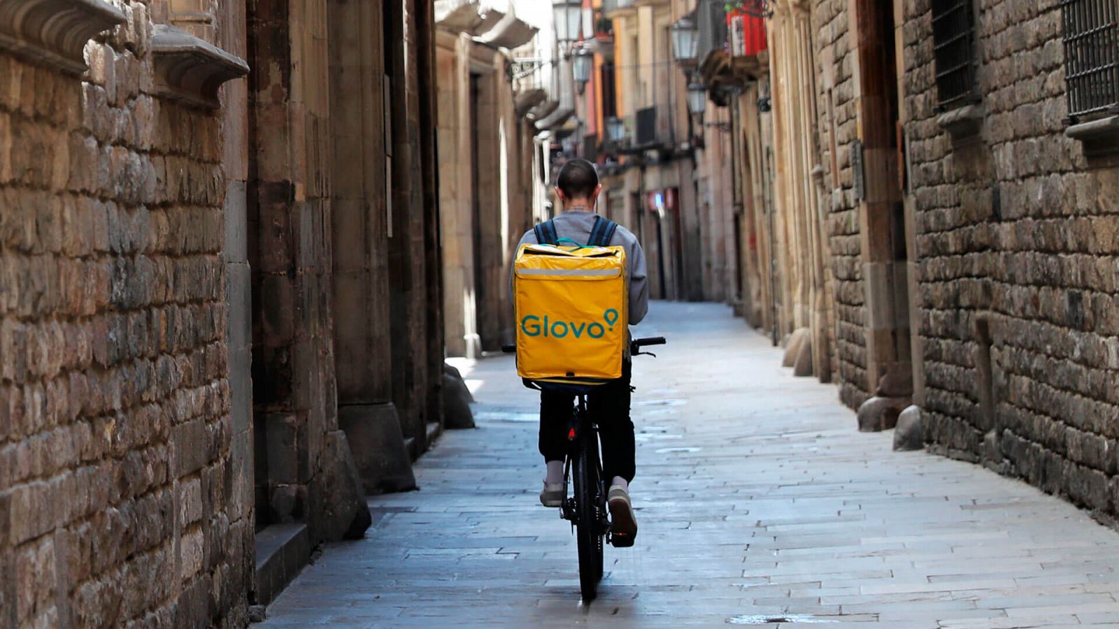 Repartidor de la plataforma Glovo en una calle solitaria de Barcelona