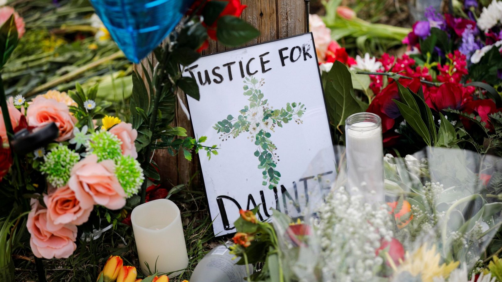 Velas, flores y un letrero se ven durante una vigilia en la esquina de 63rd Ave N y Kathrene Drive para recordar a Daunte Wright, de 20 años, quien fue asesinado por el ex oficial de policía del Brooklyn Center Kim Potter durante el fin de semana en Brooklyn Center, Minnesota, EE. UU.