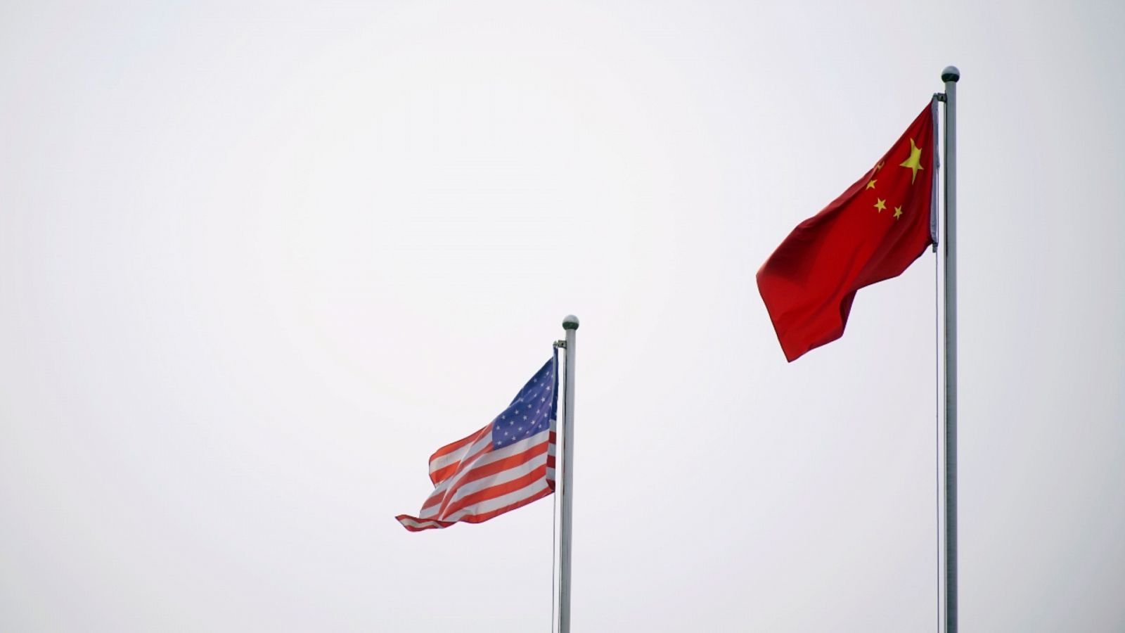 Una bandera de China y una de Estados Unidos ondeando en el exterior de un edificio en Shanghái.