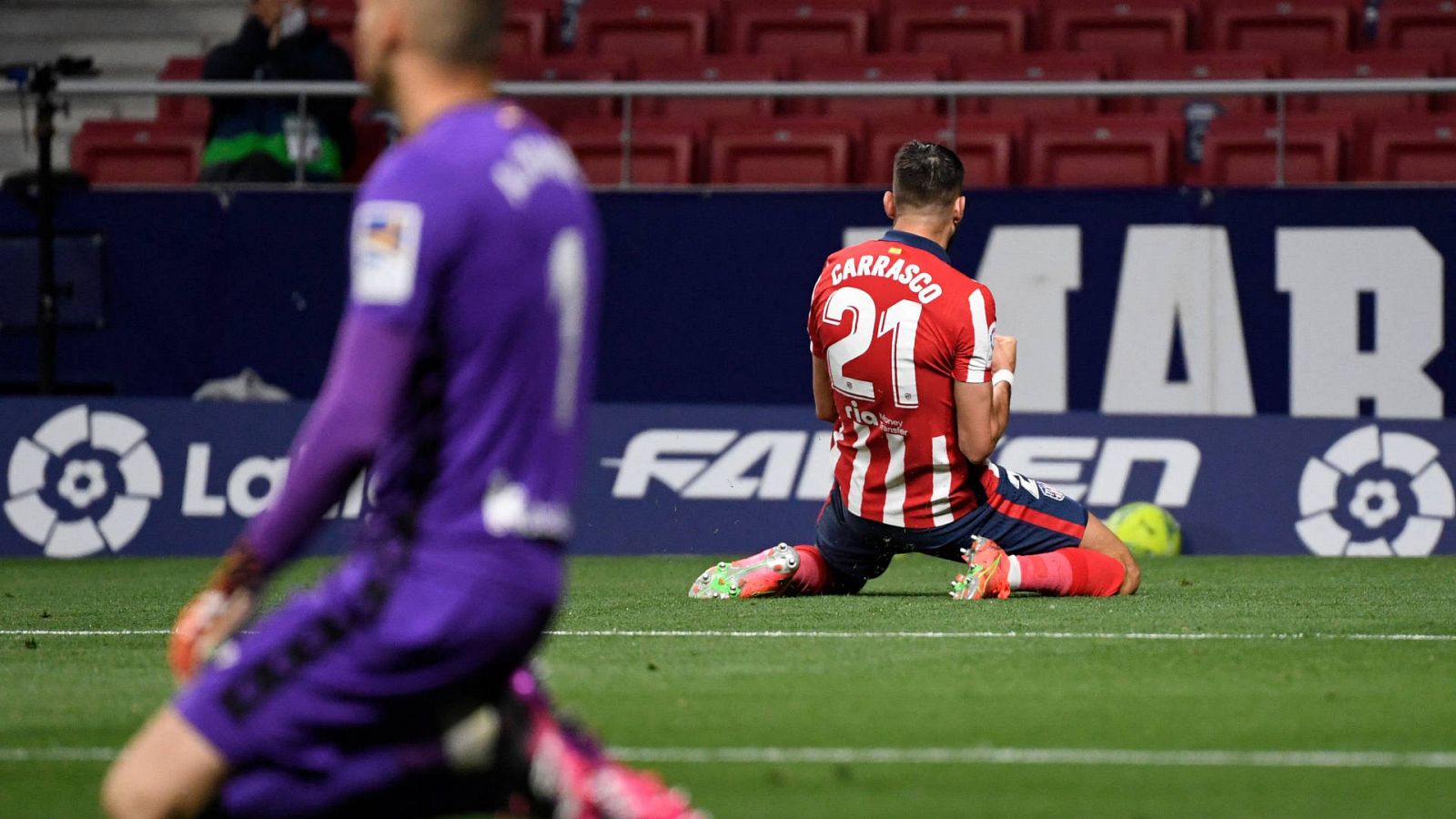 Carrasco celebra el primer gol del Atlético a la Real, cuyo portero se lamenta de rodillas en primer término (desenfocado)