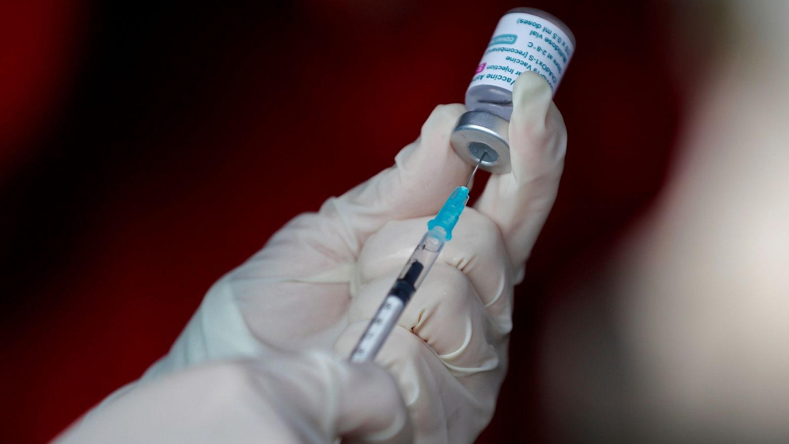 Un miembro del personal de salud sostiene una dosis de la vacuna contra la COVID-19