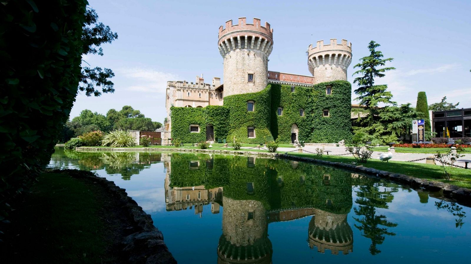 Foto general del Castell de Peralada amb les dos torres i el llac davant
