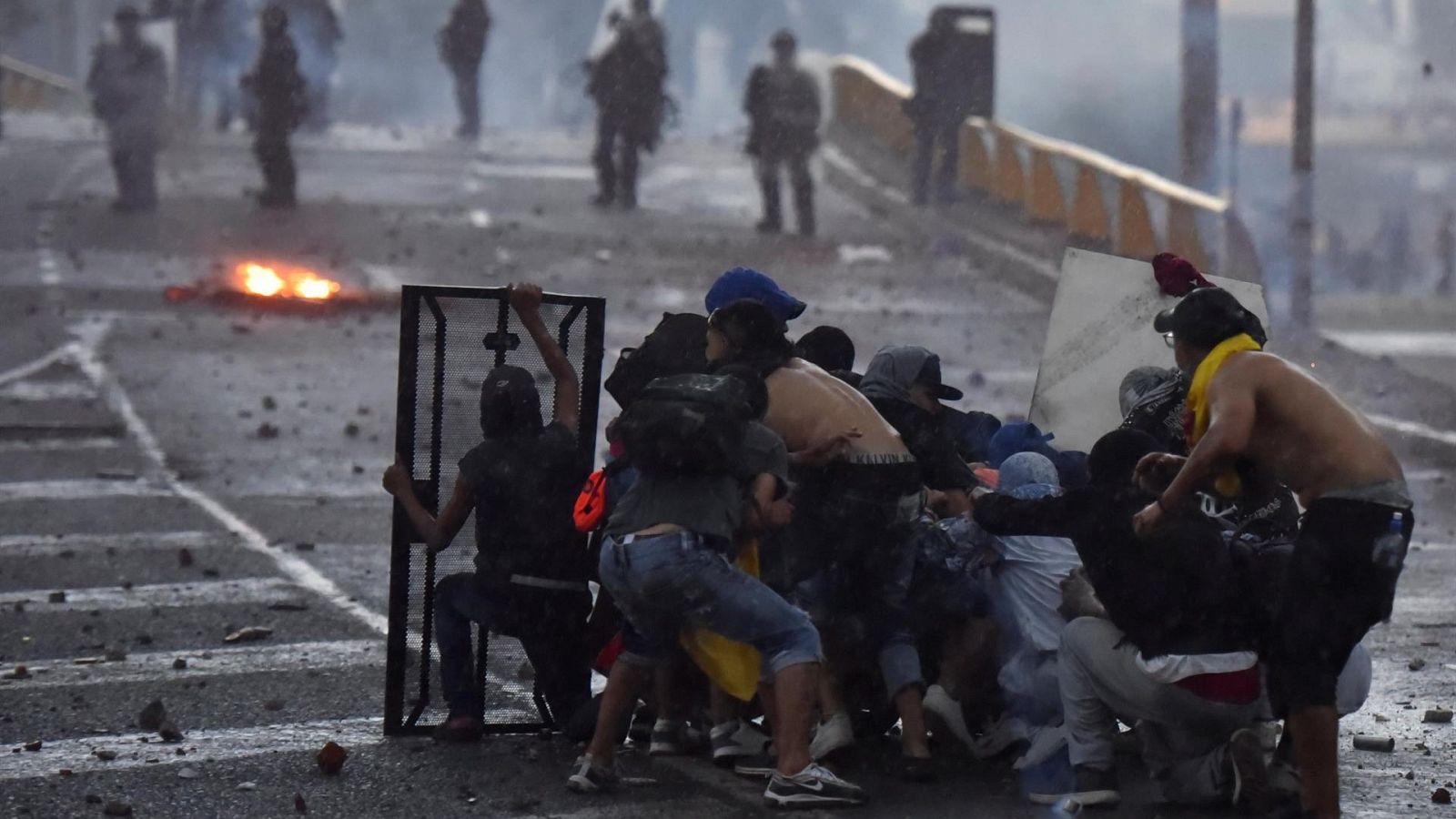 Un grupo de protestantes se parapeta frente a la policía en Colombia