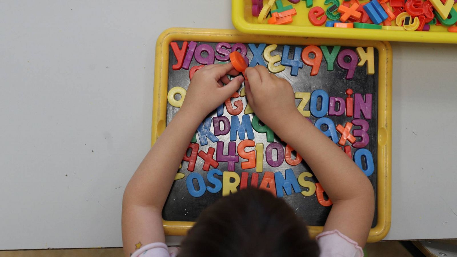 Un alumno juega con letras de colores en un aula de un colegio público de Madrid