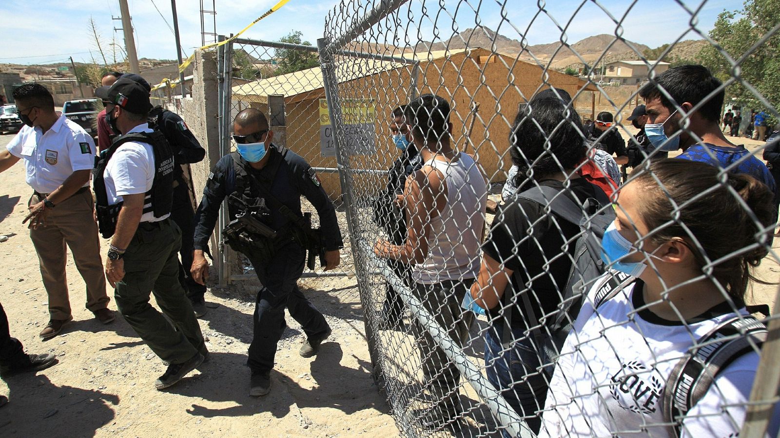 Agentes de la Policía mexicana escoltan desde una casa a más de un centenar de migrantes