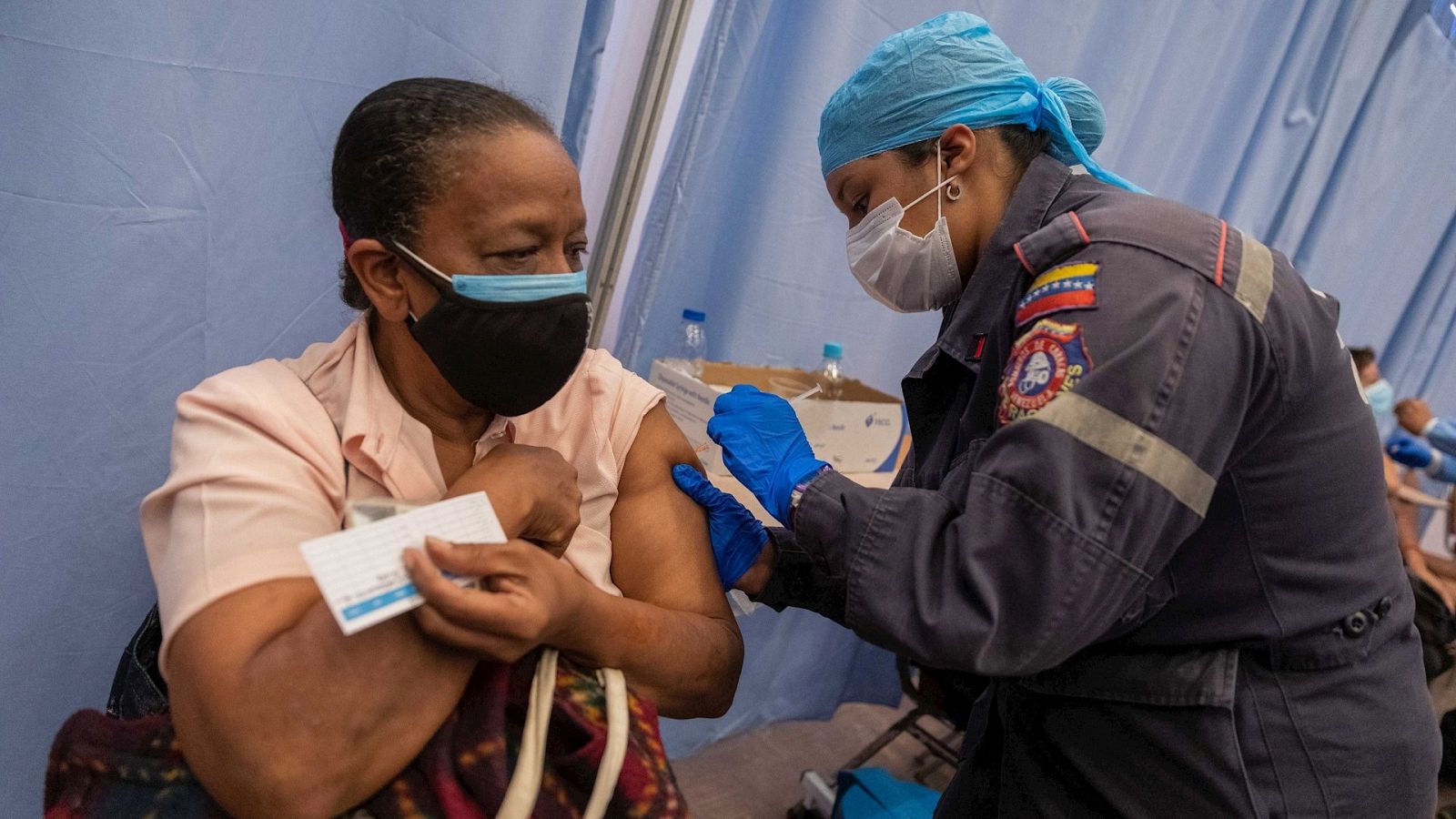 Una funcionaria aplica una dosis de la vacuna china Vero Cell a una mujer en Caracas