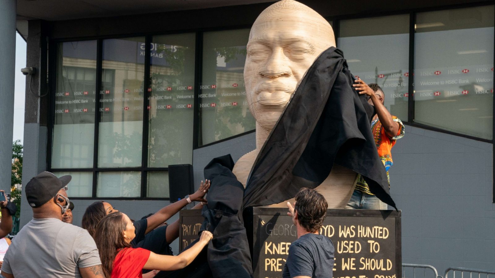 Una imagen de la inauguración de un busto de George Floyd frente a la Biblioteca pública del distrito de Brooklyn, Nueva York.
