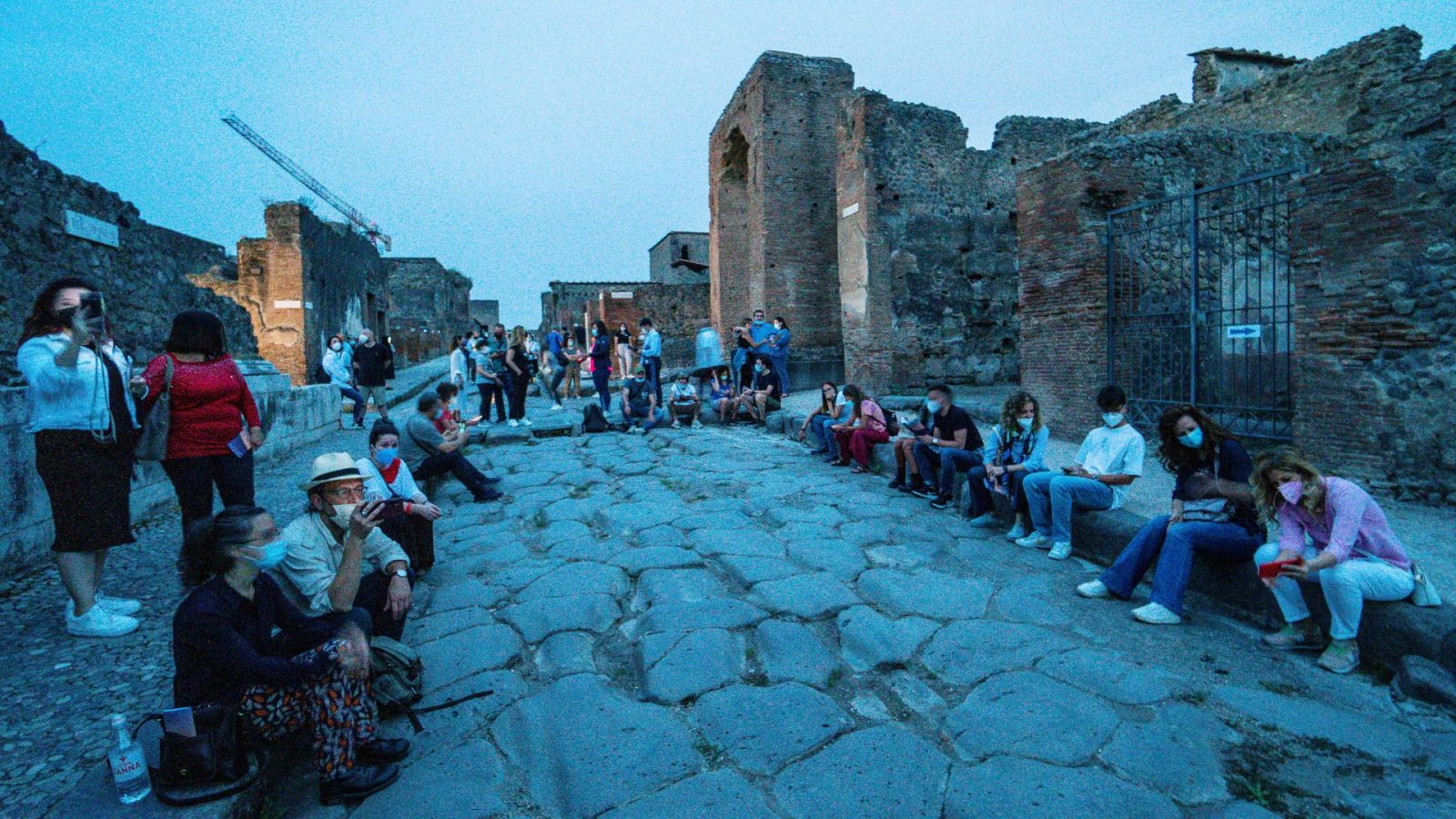 Grupo de turistas, todos con mascarilla, en Pompeya, Italia