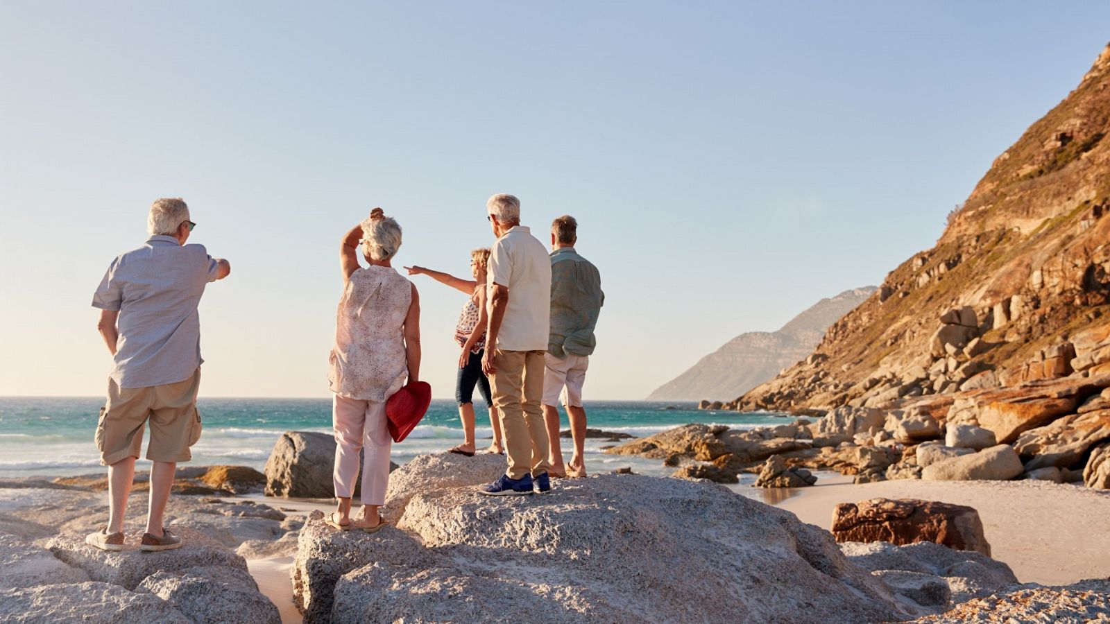 Viajes Imserso: un grupo de jubilados pasea por la playa