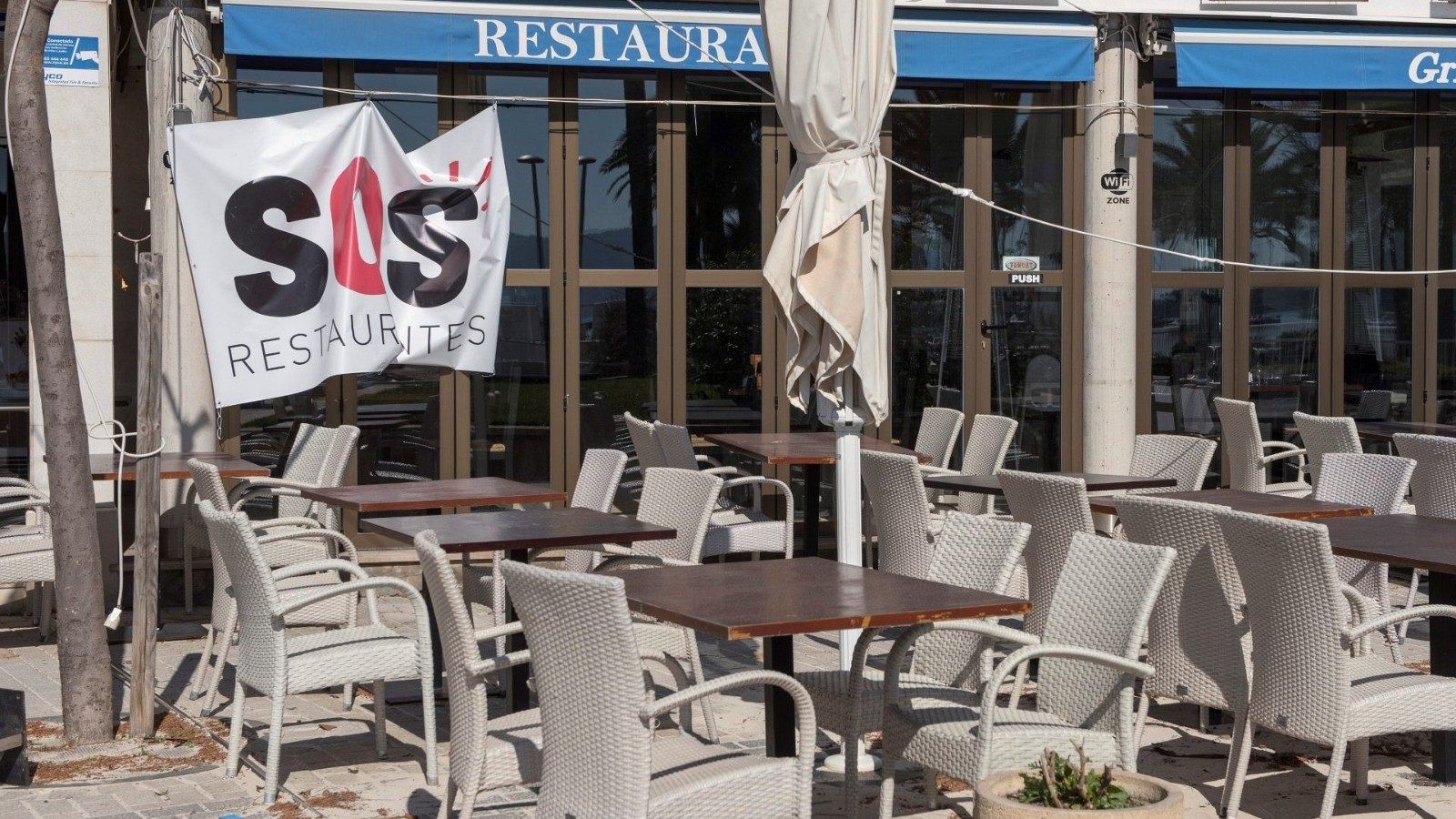 Un restaurante cerrado con la pancarta de la plataforma SOS Turismo en Pollença (Mallorca)
