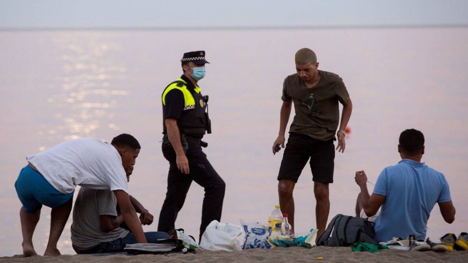 Miembros de la Policía Local de Málaga desalojan a varias personas en la playa de La Malagueta, debido al cierre de las playas para evitar aglomeraciones durante la celebración de la noche de San Juan por la crisis sanitaria del coronavirus.