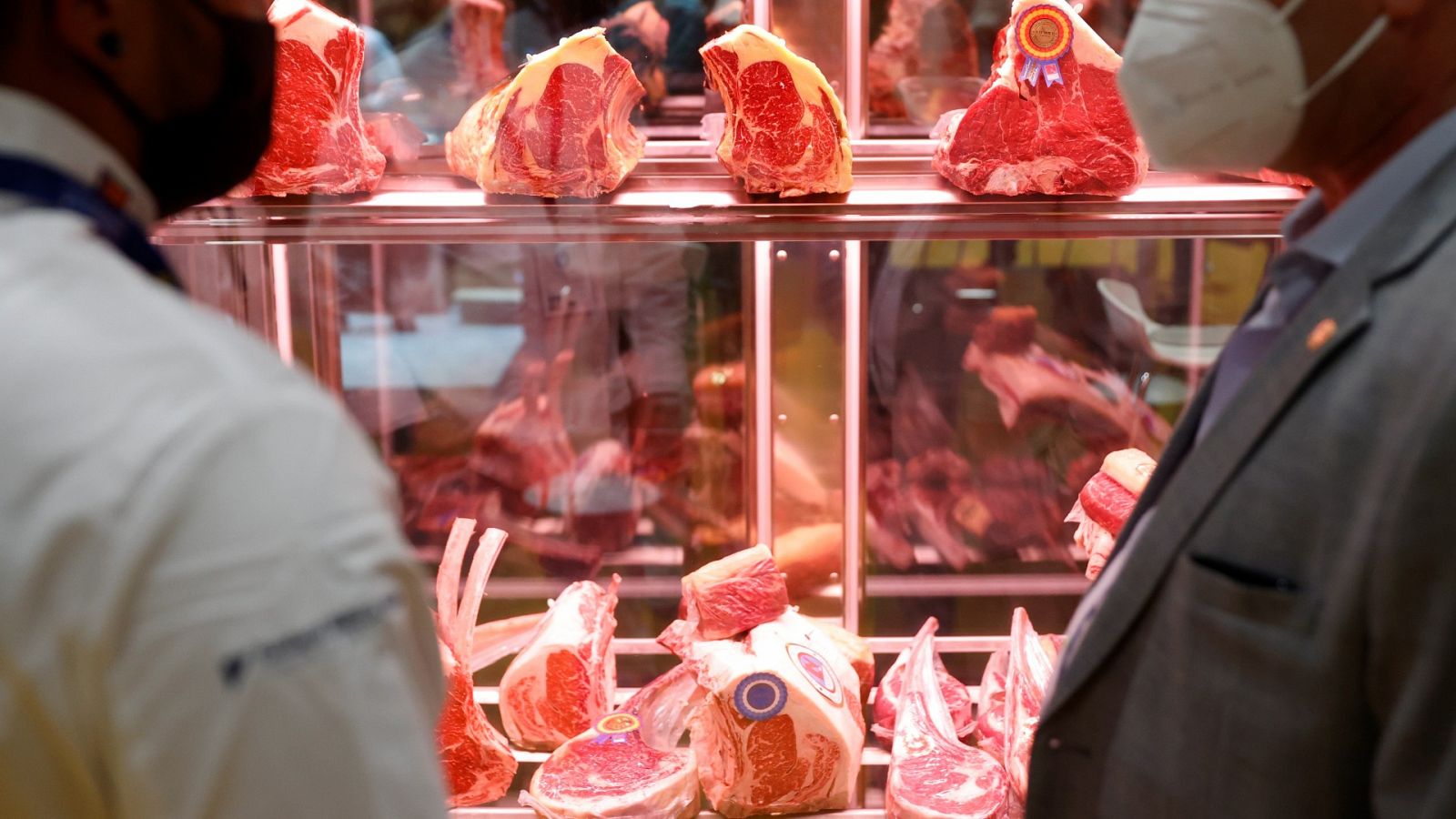 Dos profesionales conversan antes varias piezas de carne durante la jornada inaugural de Madrid Fusión,