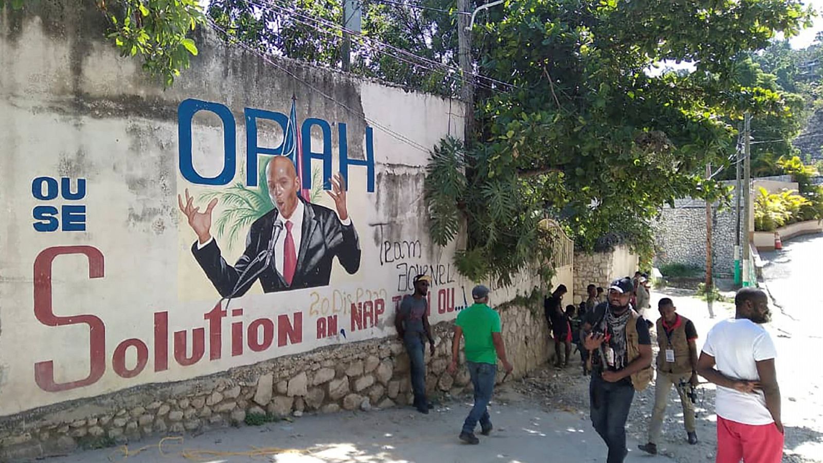 Gente pasando por delante de un mural con la imagen de Jovenel Moise en una calle de Puerto Príncipe (Haití).